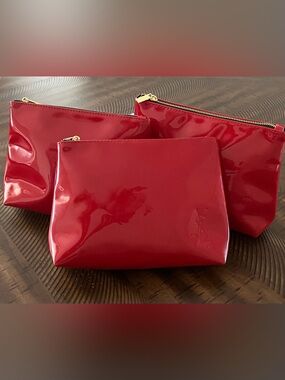Three Yves Saint Laurent Beaute cosmetic bags red patent with embossed logo